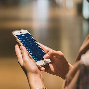 Hände, die auf einem Handy tippen